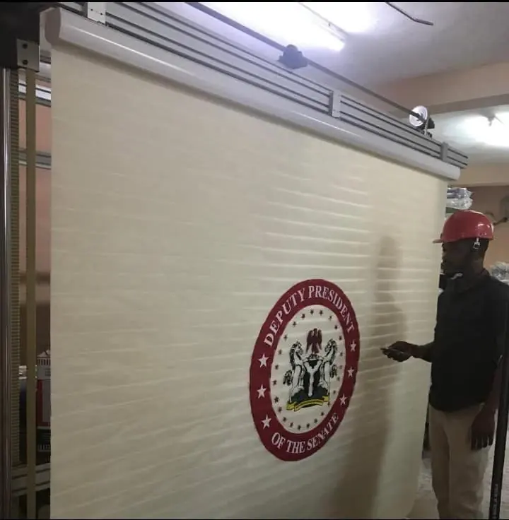 Official seal printed on a large motorised roller blind