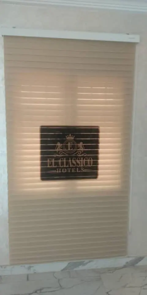 Hotel logo glowing through a zebra blind