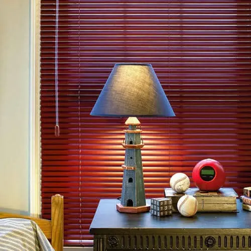 Deep red wooden blind behind a lamp